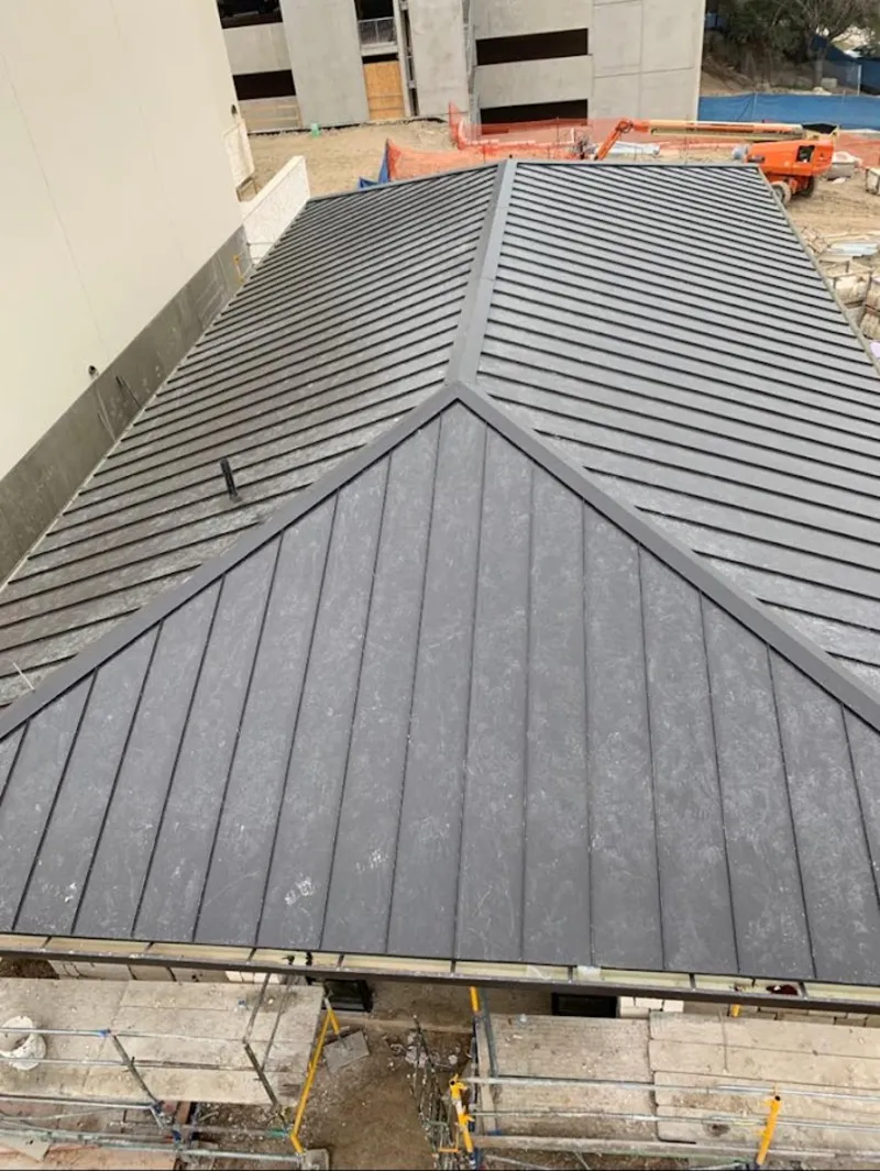 Commercial metal roof construction with crane equipment in O'Fallon